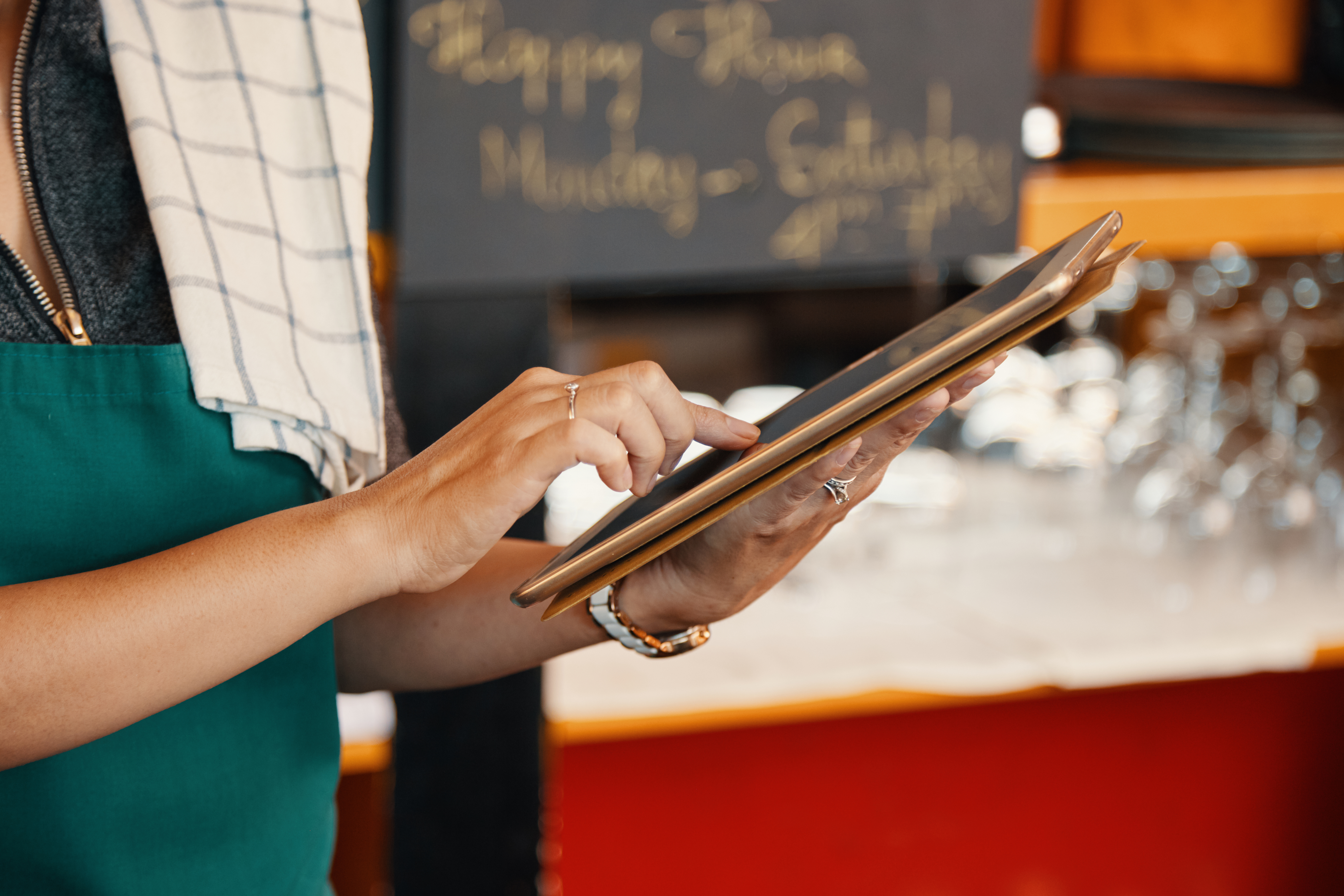Serveuse utilisant une tablette pour gérer la carte digitale du restaurant